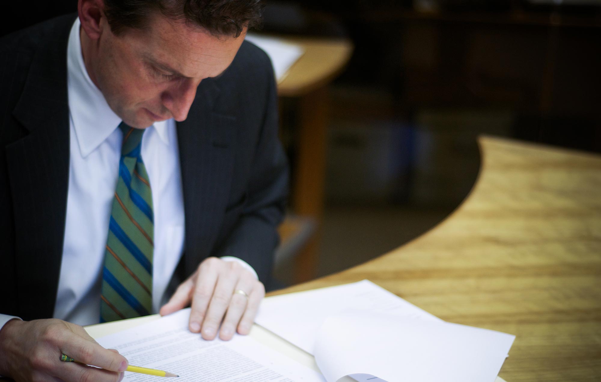 Attorney reviwing document with pencil in his hand.